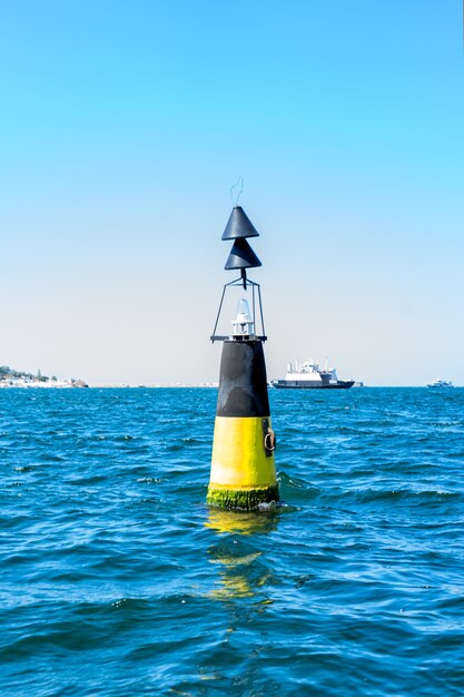 Wegwijzer voor schepen en golven in de zee, zonnige Krimzomer. Verticale oriëntatie