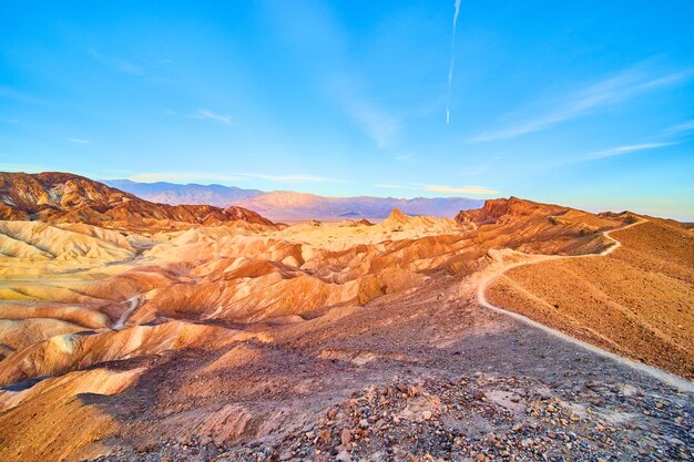 Weids uitzicht op het wandelpad langs de top van de bergen in Death Valley met kleurrijke zonsopganggolven