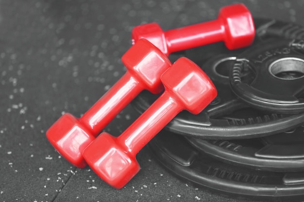 Weight plates and dumbbells on floor in gym close up