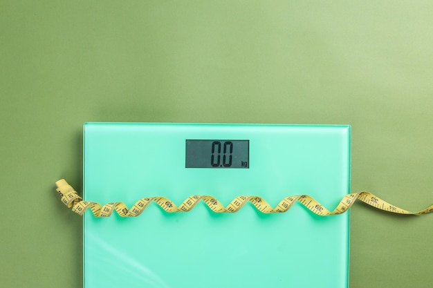 Photo weight scale with a measuring tape on green background