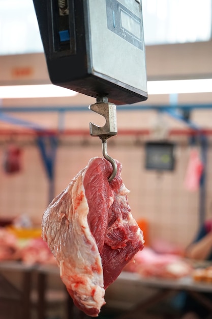 Weighting fresh raw meat in butcher shop