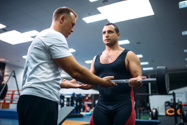 Photo weightlifter lies on bench, exercise with dumbbell