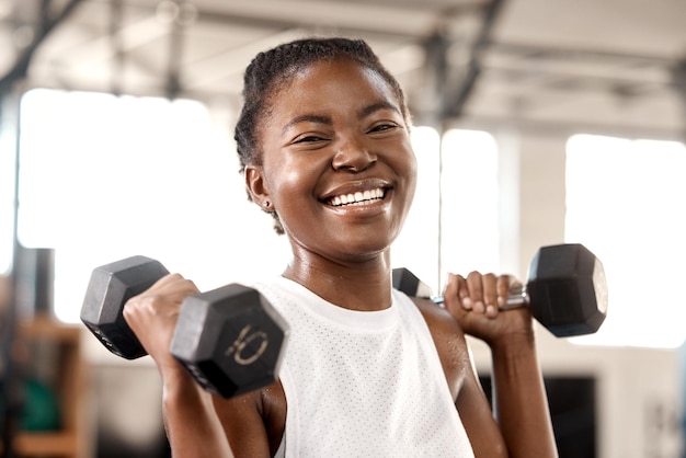 Weightlifting dumbbell and portrait with black woman in gym for workout strong and muscle Exercise weights and sports equipment with female bodybuilder in fitness center for challenge and health