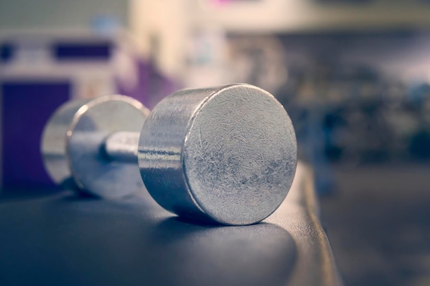 Photo weights shallow depth of field blurred foreground focused lighting on weights for emphasis dramatic lighting blurred background dust on gym mirror and not on camera sensor or lens