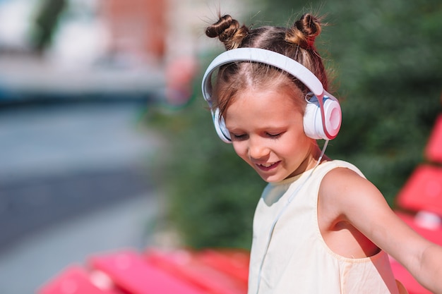 Weinig aanbiddelijke meisje het luisteren muziek in het park