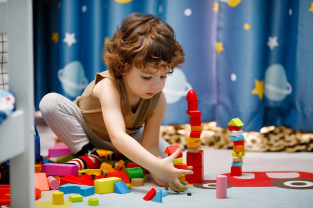 Weinig autistische jongen die met kubussen thuis speelt