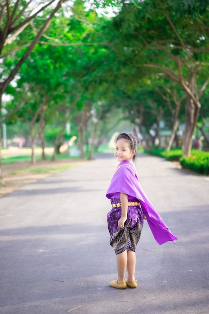 Weinig Aziatisch meisje in Thaise periodekleding die zich in het park bevindt