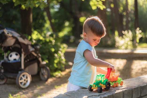 Weinig baby die met speelgoed in het park op een zonnige dag speelt