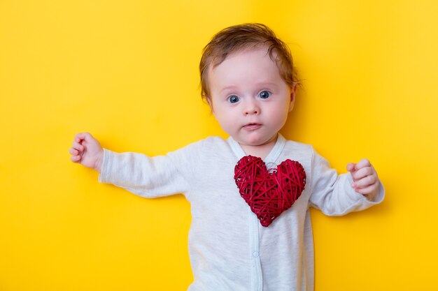 Weinig baby met rood stuk speelgoed van de hartvorm