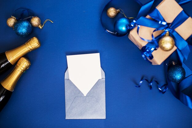 Weinig conferteren met een wit stuk papier op een blauwe achtergrond met champagne, speelgoed, geschenken.