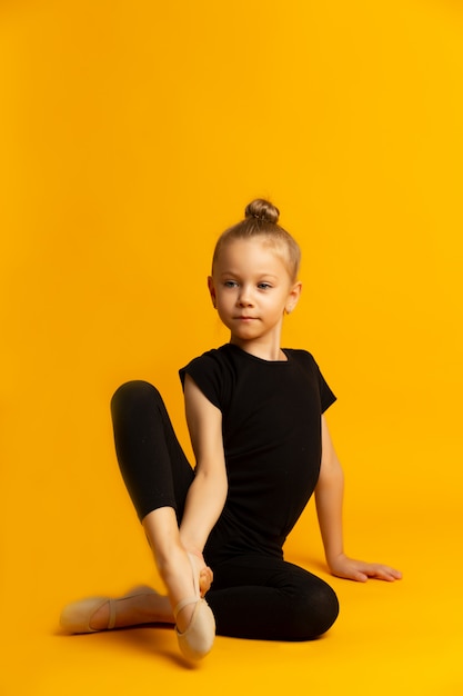 Weinig danser in turnpakje het uitrekken zich benen tijdens training