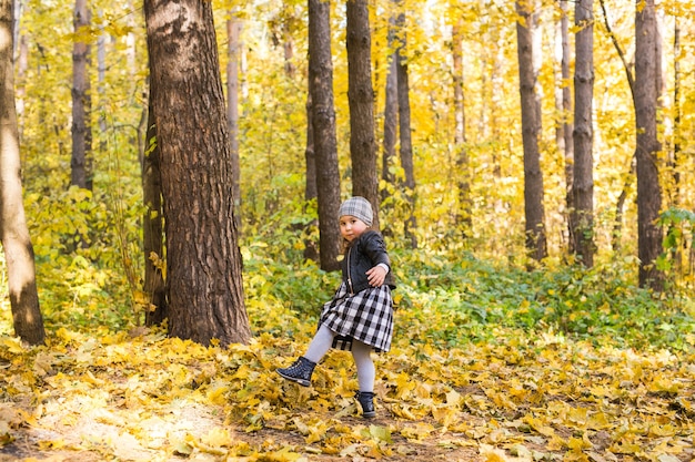 Weinig gelukkig kindmeisje die in het de herfstpark lopen