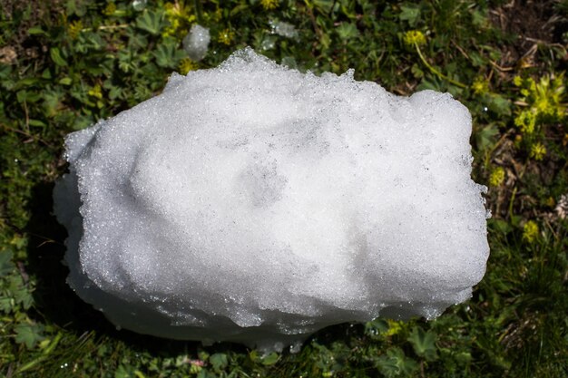 Weinig hoeveelheid sneeuw op de groene grasachtergrond