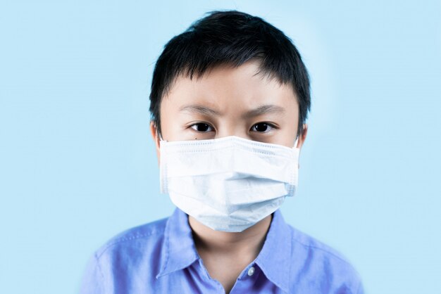 Weinig jongen die gezonde maskers draagt voor beschermt virus
