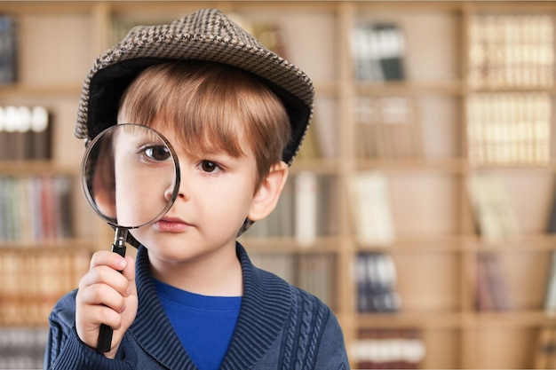 Weinig jongen die meer magnifier dicht omhoog kijken gebruiken