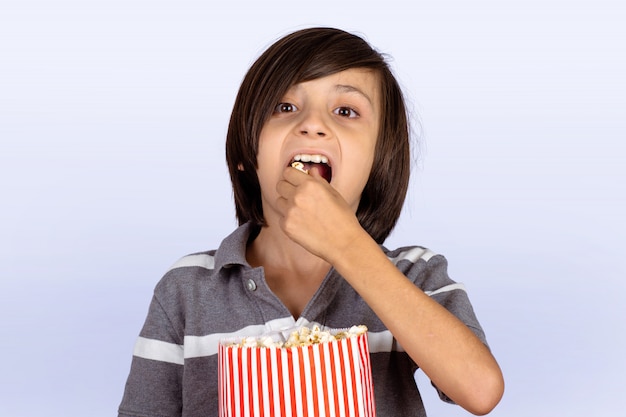 Weinig jongen die popcorn eet.