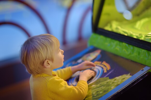 Foto weinig jongen die pret in vermaak in spelcentrum heeft