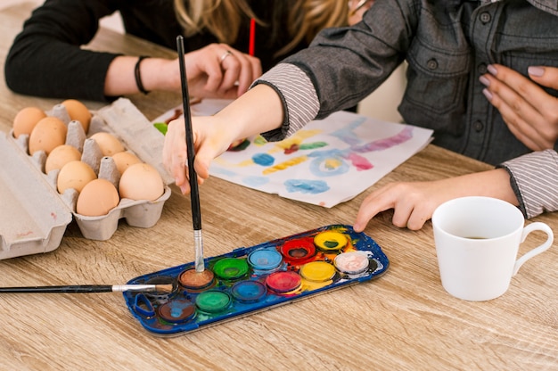 Weinig jongen en meisjes het schilderen eieren voor Pasen