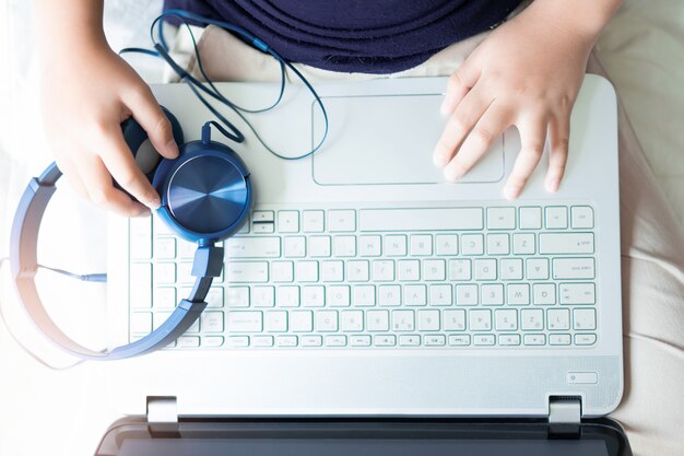 Weinig jongenshand die laptop voor spel en onderwijs met behulp van.