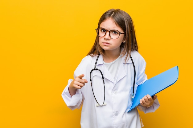 Weinig Kaukasisch meisje dat een dokterskostuum draagt