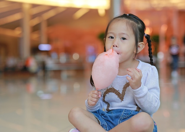 Weinig kindmeisje dat zoet sponzig suikergoed eet