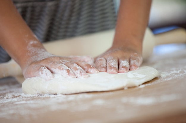 Weinig kindmeisje overhandigt het kneden deeg