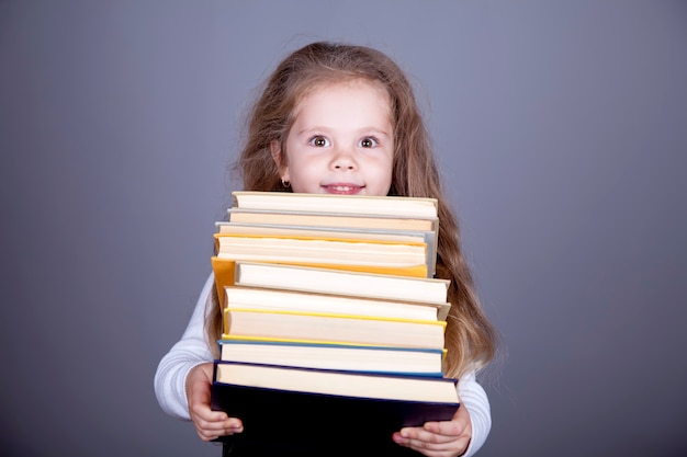 Weinig schoolmeisje met boeken.