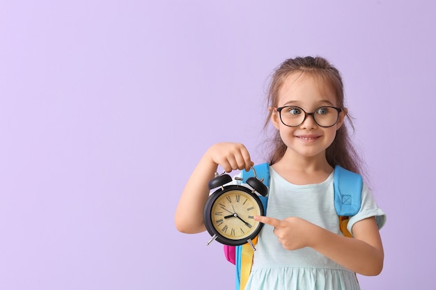 Weinig schoolmeisje met wekker. tijd om te studeren