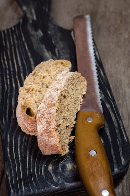 Weinig stukjes brood op houten snijplank.