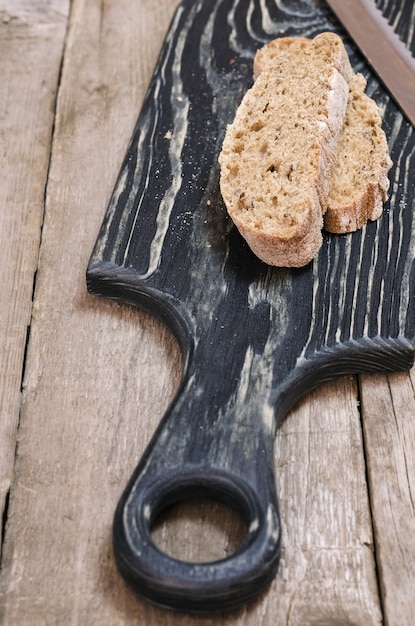 Weinig stukjes brood op houten snijplank