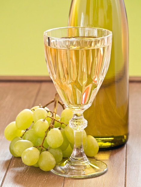 Photo weisswein im grapes glass and bottle