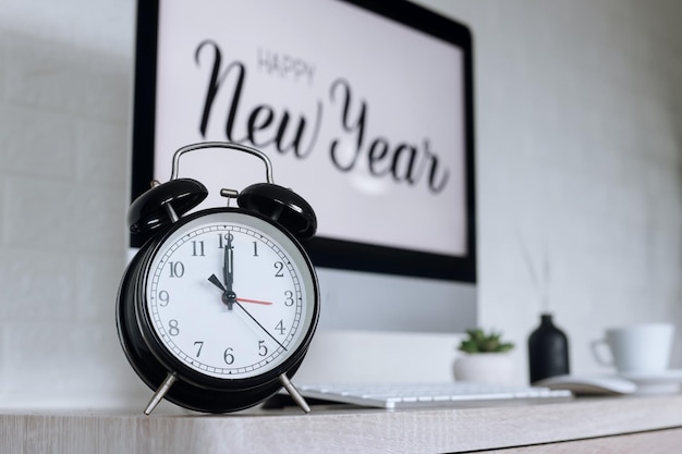 Wekker aftellen met Happy New Year-tekst op het computerscherm op de achtergrond