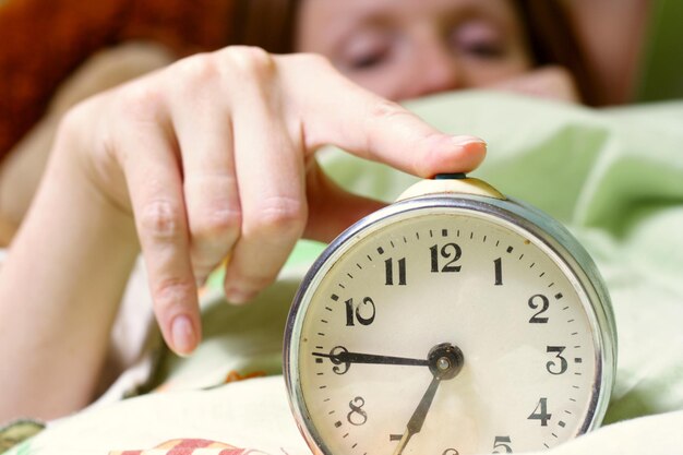 Foto wekker die een slapende vrouw stoort die onscherp is