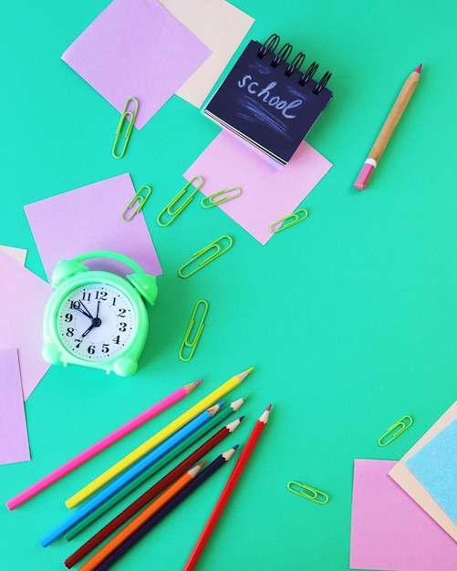 Wekker Kunstmaterialen en briefpapier op een groene achtergrond bovenaanzicht terug naar school