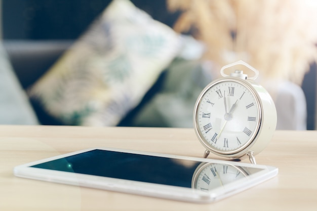 Wekker met mobiele telefoon op een houten tafel