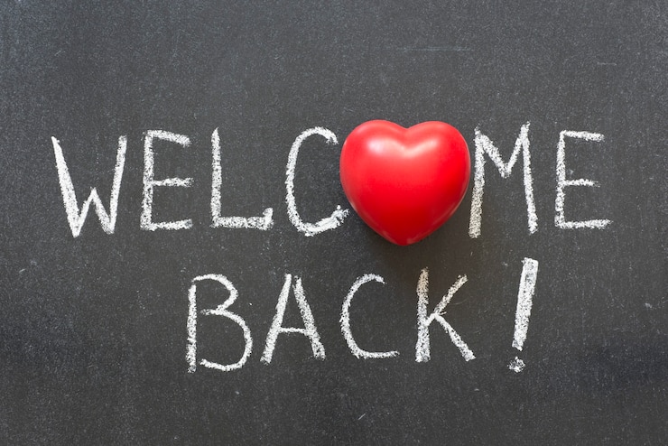 Photo welcome back phrase handwritten on chalkboard with heart symbol instead of o
