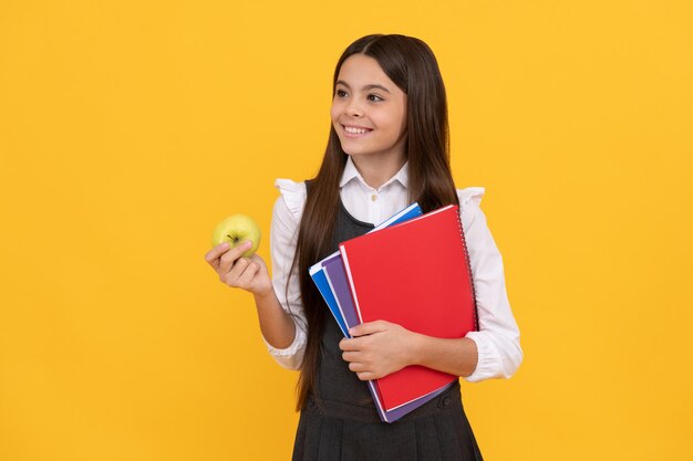 学校へようこそ。リンゴと本を持って幸せな子供の笑顔。学校に戻る。新学期。 9月1日。知識の日。基礎教育。