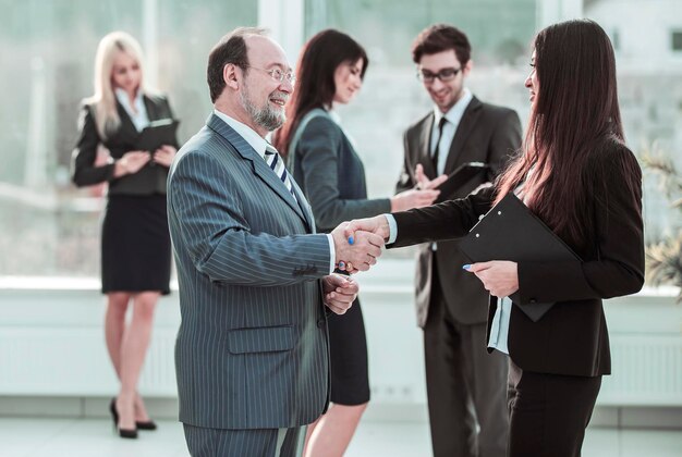 Welcome handshake between lawyer and client on the background of business team