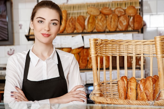 Welcome to my shop! Shot of a beautiful female baker posing in the bakery store