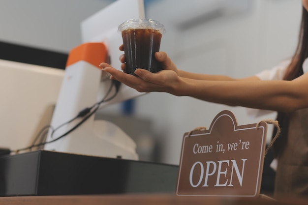 Welcome Open barista waitress woman turning open sign board on glass door in modern cafe coffee shop ready to service cafe restaurant retail store small business owner food and drink concept