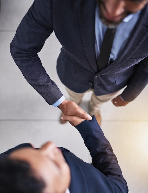 Welcome to our team High angle shot of two businessmen shaking hands in the office