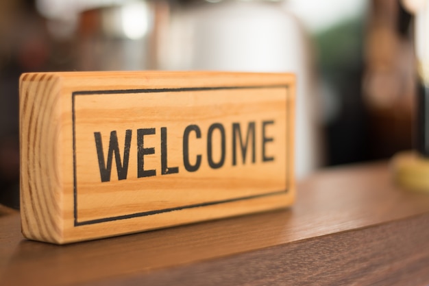 Photo welcome sign on the counter shop, business concept.