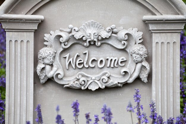 Welcome sign on stone background with lavender flower