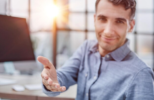 Welcome to the team business man shaking hands and smiling while sitting at the table