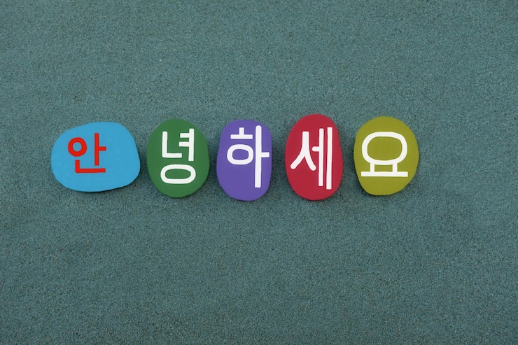 Photo 緑の砂の上に手作りの色の石の文字を組み合わせた韓国語のウェルカムテキスト
