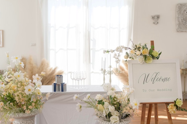 写真 花で飾られた結婚式のサインとレセプションテーブルへようこそ
