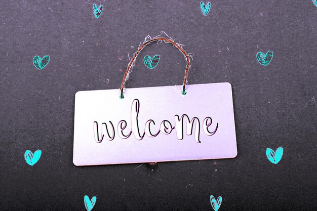 Photo welcome wording on black notice board with red hearts around