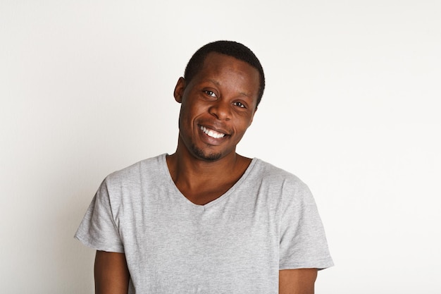 Welcoming smile. Black man smiling on white background, studio shot, copy space