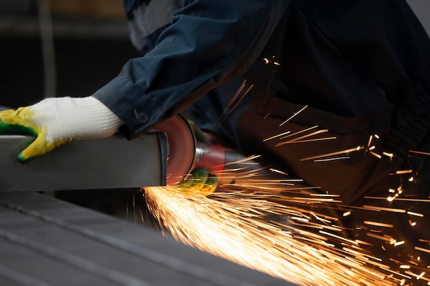 The welder cuts the pipe and fiery sparks flyWorker cuts gas pipe with grinder close up