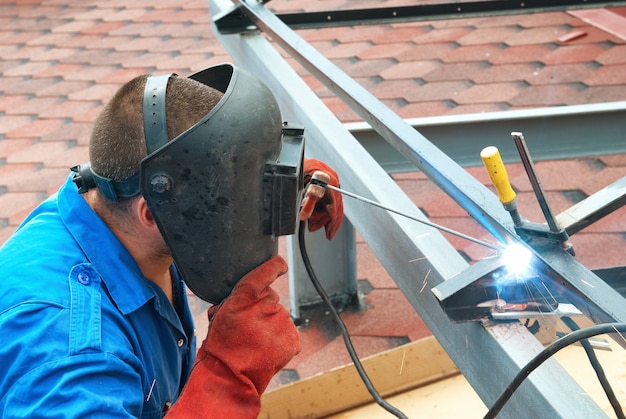 Welder at the factory working with metal construction